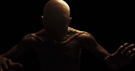 Image of distressed shirtless bald figure holding head in pain in dark room