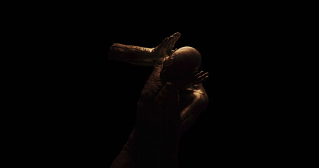 Image of distressed shirtless bald figure holding head in pain in dark room