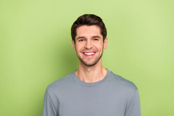 Fototapeta premium Photo of cool millennial brunet guy wear grey shirt isolated on green color background