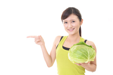 野菜を持つタンクトップ姿の女性
