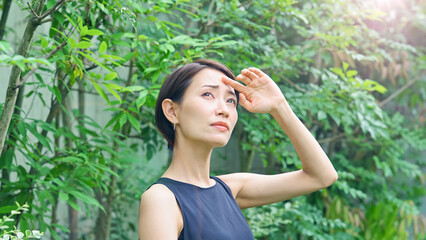 日差しを浴びて困るミドル女性　UVケア