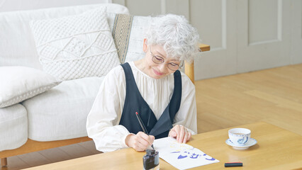 インクで文字を書くシニア女性