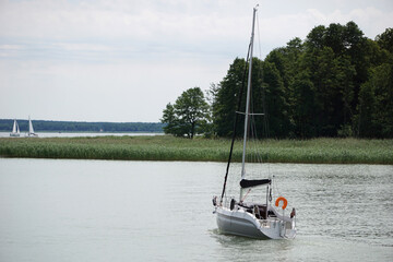 Sailboat swimming with en engine - back view