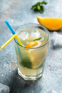 Summer sparkling cocktails. Hard seltzer cocktails with lemon, orange and mint. Glass of cold drink. vertical image. place for text
