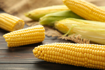 Fresh corn on cobs on rustic wooden table, closeup