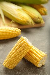 Fresh corn on cobs on grey background. Top view