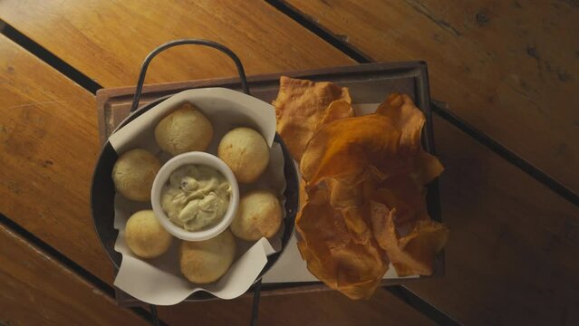 Top view of rotating served Chipa dinner with appetizer snack cheese bites, aioli and potato slices
