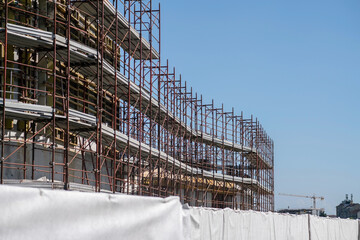 construction site & scaffolding: construction of a building, the construction site grows with the...