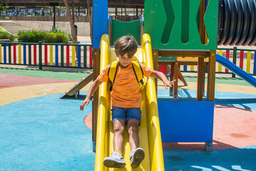 Toddler on the slide in the schoolyard. Toddler playing in the park. 