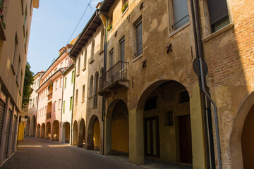Fototapeta na wymiar A quiet residential street with an arched portico in the historic centre of Treviso in Veneto, north east Italy 