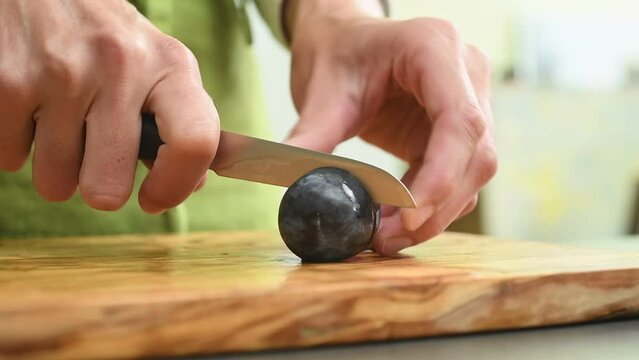 Removing the plum pit. Process of making plum jam.
