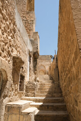 Old Mardin narrow street with stairs and old historical buildings.