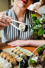 Obraz na płótnie Canvas woman eating sushi in the restaurant
