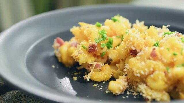 Eating of pumpkin mac and cheese, served in a plate.
