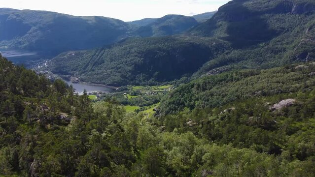 Flight over the mountains. The nature of Norway goths and the village at the bottom of the valley near the river and fjord
