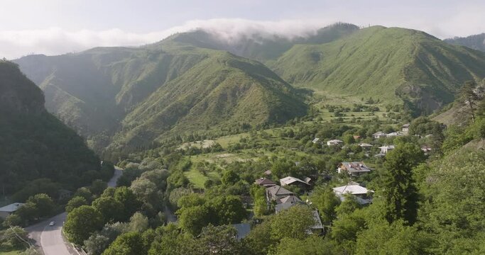 Aerial View Of Daba Settlement And Green Mountain Range At Summer In Georgia. - pullback
