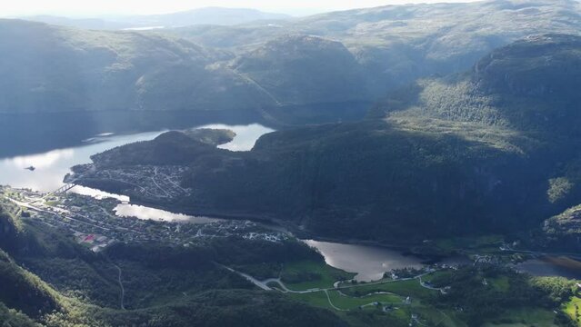 Flight over the mountains. The nature of Norway goths and the village at the bottom of the valley near the river and fjord