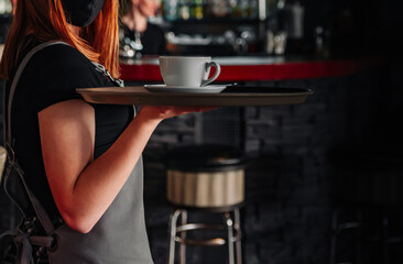 waiter holds in bunches a tray with cup. Restaurant service