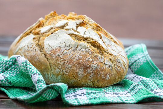 A loaf of wheat bread on a tea towel