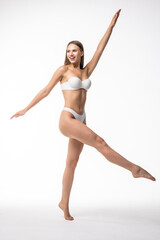 Full length portrait of smiling young woman in lingerie on white background