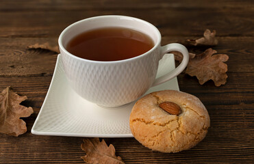 Gluten free italian cookies and almond on saucer and autumn dry oak leaves. Retro style. Almond cookies. Sicilian traditional almond biscuits. Biscotti di mandorla siciliani. High quality