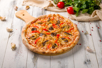 Italian meat pizza on a white wooden table