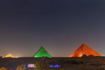 The pyramids floodlit at night, Giza, Egypt