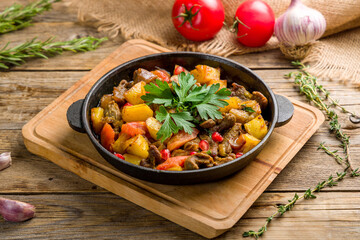 pan-fried beef with potatoes on old wooden table