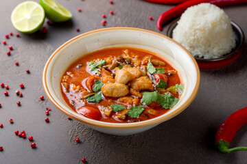 Tom Yam soup with chicken on brown table