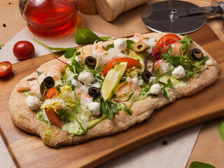 italian pizza with shrimp on a wooden board in the restaurant