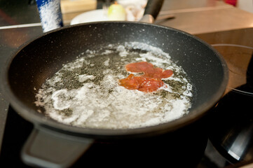 Cook fries meat in a pan with vegetables.