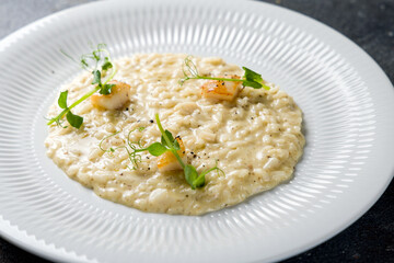 risotto with scallops and truffle oil on white plate macro close up