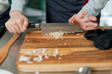 The cook cuts vegetables with a knife to prepare the dish. Cutting vegetables.