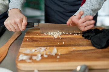 The cook cuts vegetables with a knife to prepare the dish. Cutting vegetables.