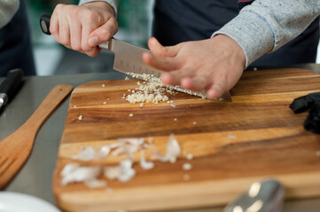 The cook cuts vegetables with a knife to prepare the dish. Cutting vegetables.