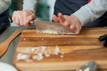 The cook cuts vegetables with a knife to prepare the dish. Cutting vegetables.