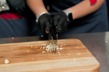The cook cuts vegetables with a knife to prepare the dish. Cutting vegetables.
