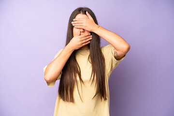 hispanic pretty woman covering face with both hands saying no to the camera! refusing pictures or...