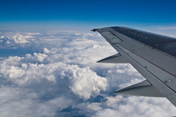 Blick aus einem Flugzeugfenster über den Wolken