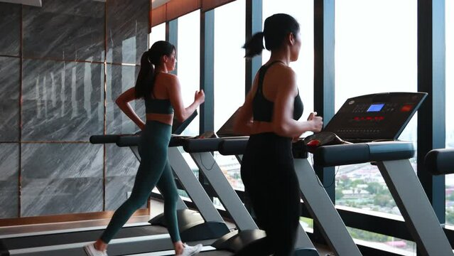 Sporty asia woman  exercising on multistation at gym for arm and shoulders muscles. Fitness exercising in gym at condo