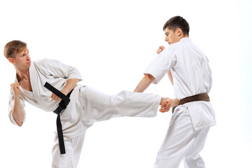 Two athletes, karate-do fighters in doboks practicing karate isolated on white background. Concept...