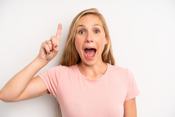 blonde pretty woman feeling like a happy and excited genius after realizing an idea, cheerfully...