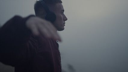 Inspired man dancing headphones on beach. Guy listening music in earphones