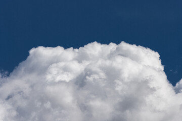 Naklejka na ściany i meble White cumulus clouds against a dark blue sky natural background weather change wind