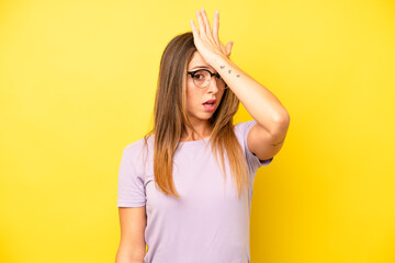 pretty young adult woman raising palm to forehead thinking oops, after making a stupid mistake or...