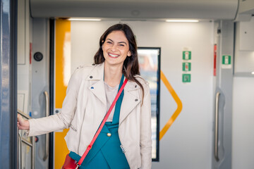 Potrait of beautiful traveler woman getting off the train smiling - Young business woman peeking...