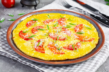 Omelette with tomatoes, herbs and grated cheese. Easy breakfast