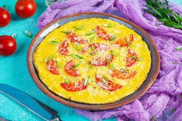 Omelette with tomatoes, herbs and grated cheese. Easy breakfast