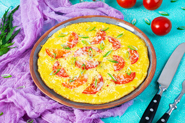 Omelette with tomatoes, herbs and grated cheese. Easy breakfast