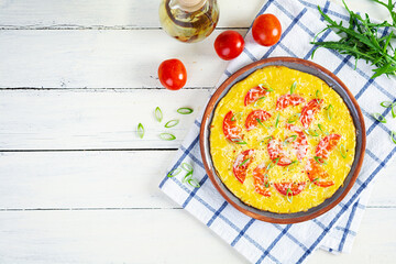 Omelette with tomatoes, herbs and grated cheese. Easy breakfast